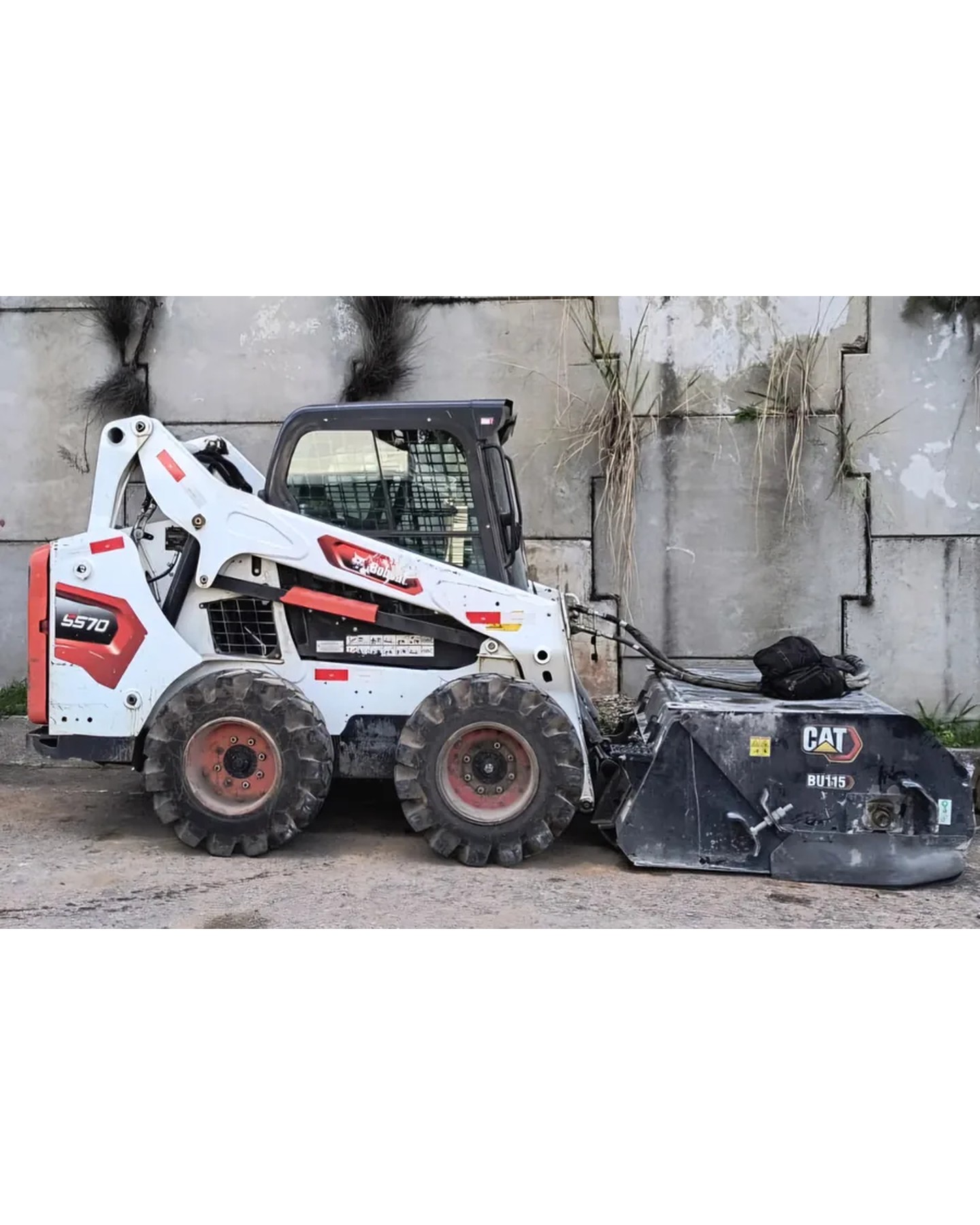 Bobcat com vassoura recolhedora limpando pátio em Curitiba