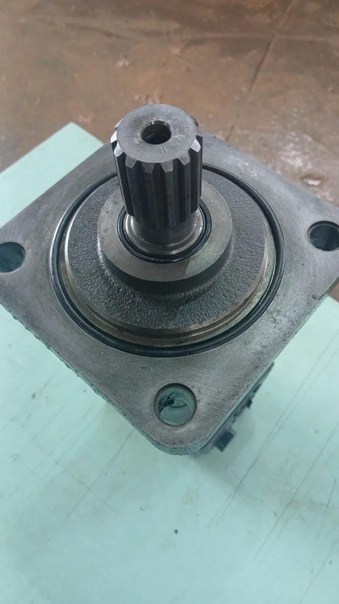 Motor hidráulico orbital recondicionado, detalhe do eixo estriado e flange